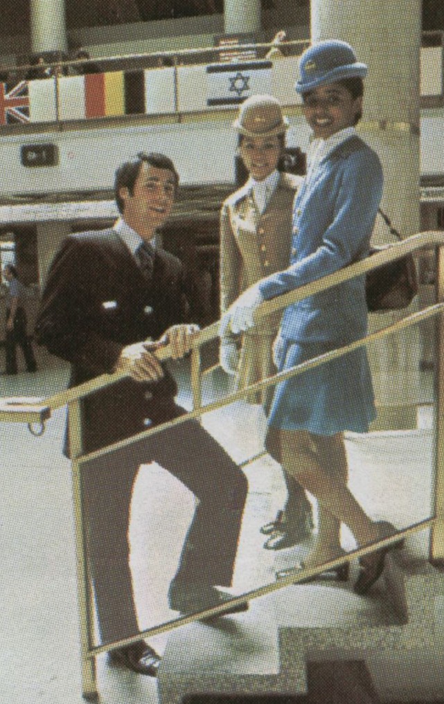 Early 1970s  two female flight attendants and thier male counterpart pose on steps leading to the upstairs restaurant at Pan Am's New York, JFK 